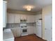 Well-lit kitchen features white cabinets, a tile backsplash, wooden floor and modern appliances at 3259 S Pointe Ct, Atlanta, GA 30340
