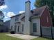 The rear exterior shows a home with a white siding with a brick chimney and a grassy backyard at 3259 S Pointe Ct, Atlanta, GA 30340
