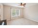 Cozy bedroom with neutral tones, a ceiling fan, and natural light from a large window at 2138 Bramlett Nw Pl, Marietta, GA 30064