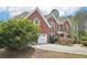 Two-story brick home with a well-manicured lawn and tree at 2138 Bramlett Nw Pl, Marietta, GA 30064