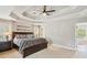 Spacious main bedroom features tray ceilings, a ceiling fan, and an adjoining bathroom with tub at 2138 Bramlett Nw Pl, Marietta, GA 30064