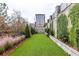 Backyard features artificial turf, a stone retaining wall with planted greenery, and mature trees at 3933 Danube Ln # 224, Atlanta, GA 30339