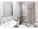 A modern bathroom with a sliding glass shower door, a white sink, and a toilet at 3933 Danube Ln # 224, Atlanta, GA 30339