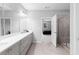 Bathroom features grey cabinets, double vanity, tiled shower, and view into bedroom at 3933 Danube Ln # 224, Atlanta, GA 30339