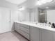 Bathroom featuring grey cabinets, double vanity, and large mirror at 3933 Danube Ln # 224, Atlanta, GA 30339