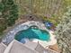 Aerial view of a backyard featuring a kidney-shaped pool, lounge seating, and lush landscaping for ultimate relaxation at 4215 Homestead Ridge Dr, Cumming, GA 30041