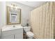 Bright bathroom with a gold framed mirror, white vanity, and patterned shower curtain at 4215 Homestead Ridge Dr, Cumming, GA 30041