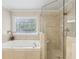 Bathroom featuring glass enclosed shower, soaking tub, and patterned privacy window at 4215 Homestead Ridge Dr, Cumming, GA 30041