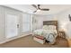 Bedroom with a wood headboard, fan, neutral walls, and doors leading to a private balcony at 4215 Homestead Ridge Dr, Cumming, GA 30041