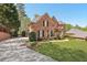 Spacious brick home with an expansive front lawn, long driveway, mature trees, and meticulous landscaping at 4215 Homestead Ridge Dr, Cumming, GA 30041
