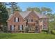 Elegant brick home with manicured landscaping, arched entry, and a classic, inviting facade in a serene setting at 4215 Homestead Ridge Dr, Cumming, GA 30041