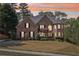 A brick house featuring a well-manicured lawn and attractive landscaping, providing great curb appeal at 4215 Homestead Ridge Dr, Cumming, GA 30041