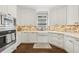 Bright kitchen features stainless steel appliances, white cabinetry, and modern brick backsplash at 4215 Homestead Ridge Dr, Cumming, GA 30041