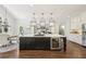 Gourmet kitchen features island with wine fridge, cooktop, and hanging pendant lights at 4215 Homestead Ridge Dr, Cumming, GA 30041