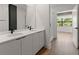 Bright bathroom with dual sinks, white cabinetry, and doorway leading to bedroom at 108 Park Place Unit 104, Decatur, GA 30030