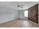 Comfortable bedroom with hardwood floors, ceiling fan, and unique stone accent wall at 6691 Colchester Pl, Norcross, GA 30093