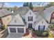Attractive two-story home featuring a manicured lawn, gray-tone garage doors, and a welcoming entryway at 1055 Crabapple Parc Dr, Roswell, GA 30076