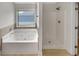 Bright bathroom featuring a soaking tub, shower and window with a view at 120 Madison Grace Ave, Mcdonough, GA 30252