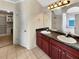 Bathroom with dual sinks, granite countertops, and a doorway leading to a custom closet at 120 Madison Grace Ave, Mcdonough, GA 30252