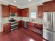 Modern kitchen featuring stainless steel appliances and dark wood cabinets at 120 Madison Grace Ave, Mcdonough, GA 30252