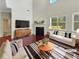 Bright, staged living room with high ceilings, a fireplace, and large windows at 120 Madison Grace Ave, Mcdonough, GA 30252