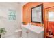 Bright bathroom with white cabinets, chrome faucet and an orange accent wall at 2344 Belmont Dr, Decatur, GA 30032