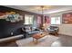 A living area with dark walls, artistic decor, hardwood floors, and comfortable seating at 2344 Belmont Dr, Decatur, GA 30032