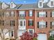 Charming brick townhome featuring a bay window, dormers, black shutters, and a two-car garage at 4908 Waters Edge Trl, Roswell, GA 30075