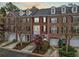 Attractive brick townhome boasting dormer windows, black shutters, two-car garage, and well-kept landscaping at 4908 Waters Edge Trl, Roswell, GA 30075
