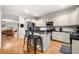 Bright kitchen with white cabinetry, a central island with seating, and hardwood floors flowing into the living area at 4908 Waters Edge Trl, Roswell, GA 30075