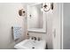 Elegant powder room featuring pedestal sink, decorative mirror, and stylish sconces offering soft lighting at 4908 Waters Edge Trl, Roswell, GA 30075