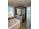 Modern bathroom with a glass-enclosed shower, soaking tub, and grey tiled walls at 95 Kendall Ln, Covington, GA 30014