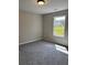 Bedroom with neutral walls, carpet flooring, and a window providing ample natural light at 95 Kendall Ln, Covington, GA 30014