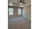 Bright main bedroom with a tray ceiling, ceiling fan and two windows offering wooded views at 95 Kendall Ln, Covington, GA 30014