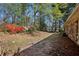 Backyard features a brick home with seasonal flowers and mature trees at 3712 Spring Hill Se Rd, Smyrna, GA 30080