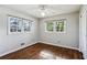 A bright bedroom with hardwood floors, a ceiling fan, and two windows at 3712 Spring Hill Se Rd, Smyrna, GA 30080