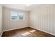 This bedroom features decorative wall paneling, hardwood floors, and a window at 3712 Spring Hill Se Rd, Smyrna, GA 30080
