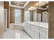 Bathroom featuring dual sinks, white cabinets and a corner garden tub with window views at 4385 Old Hamilton Mill Rd, Buford, GA 30518