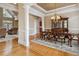 Spacious dining room featuring hardwood floors, decorative columns, and a view into the formal living room at 4385 Old Hamilton Mill Rd, Buford, GA 30518