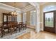 Elegant dining room featuring a dark wood table, a china cabinet, and a coffered ceiling with decorative chandelier at 4385 Old Hamilton Mill Rd, Buford, GA 30518