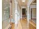 Elegant foyer with hardwood floors, decorative columns, and a glimpse into a living room with a stone fireplace at 4385 Old Hamilton Mill Rd, Buford, GA 30518