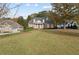 Beautiful brick home with stately columns, lush landscaping, and a sprawling green lawn surrounded by mature trees at 4385 Old Hamilton Mill Rd, Buford, GA 30518