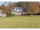 Stately brick home featuring classic white columns, lush landscaping, and a spacious front lawn with mature trees at 4385 Old Hamilton Mill Rd, Buford, GA 30518