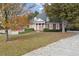 Elegant brick home with white columns, manicured landscaping, and a spacious front yard adorned with autumn foliage at 4385 Old Hamilton Mill Rd, Buford, GA 30518