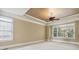 Main bedroom featuring tray ceilings, ceiling fan and many bright windows at 4385 Old Hamilton Mill Rd, Buford, GA 30518
