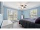 Bright bedroom with updated floors, ceiling fan, and natural light from large windows at 1601 Sycamore Nw Dr, Kennesaw, GA 30152