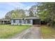 Inviting home with light blue siding, black trim, driveway, and an attached carport at 1601 Sycamore Nw Dr, Kennesaw, GA 30152