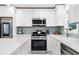 A well-appointed kitchen with white cabinets, stainless steel appliances, and stylish backsplash at 1601 Sycamore Nw Dr, Kennesaw, GA 30152