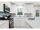 Bright kitchen features white cabinetry, stainless appliances, and attractive backsplash at 1601 Sycamore Nw Dr, Kennesaw, GA 30152