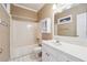 White tiled bathroom with white cabinets and combination tub and shower at 2973 Heavenly Ln, Snellville, GA 30078